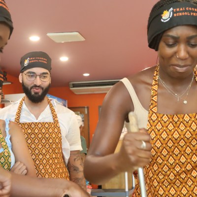 Group in matching aprons engaging in a cooking activity.